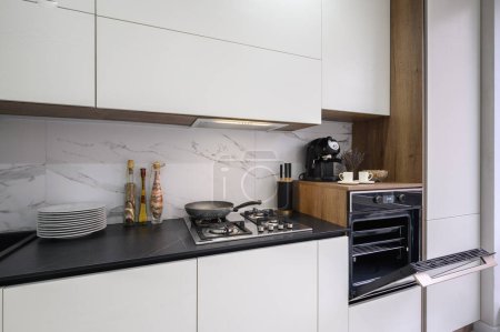 Téléchargez les photos : Meubles de cuisine de luxe modernes blancs avec plan de travail de comptoir noir - en image libre de droit