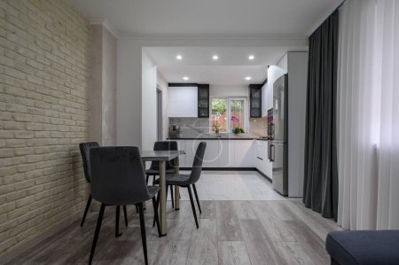 Un apartamento estudio recientemente renovado con una amplia, moderna y bien diseñada cocina blanca y comedor