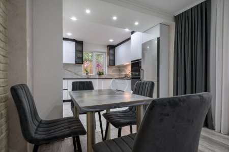 Un apartamento estudio con una hermosa cocina blanca y comedor que ha sido renovado para ser moderno y funcional