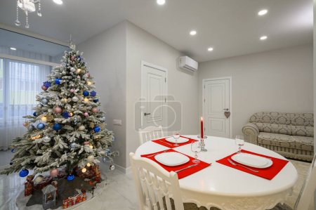 Téléchargez les photos : Intérieur de cuisine moderne lumineuse avec table à manger décorée avec arbre de Noël - en image libre de droit