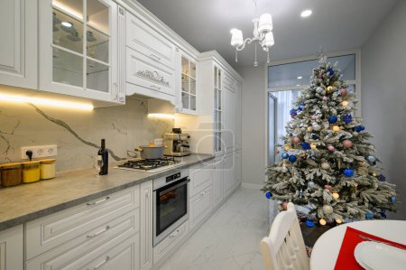 Foto de Interior de la cocina moderna y luminosa decorada con árbol de Navidad - Imagen libre de derechos