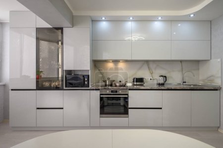 Photo for Interior of well designed modern trendy white kitchen, front view - Royalty Free Image