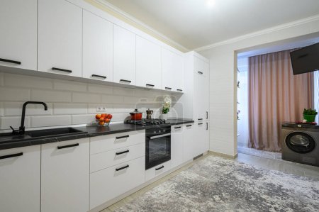 Téléchargez les photos : Vitrine intérieure de cuisine moderne blanche neige tendance avec des meubles minimalistes - en image libre de droit