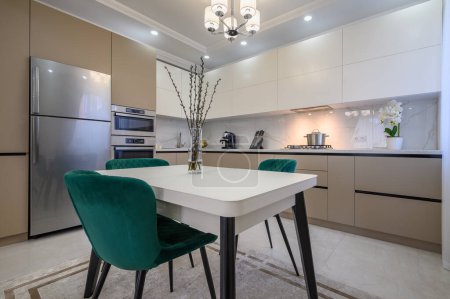 Foto de Moderna cocina clásica de lujo blanca y beige con comedor en el interior del apartamento estudio - Imagen libre de derechos