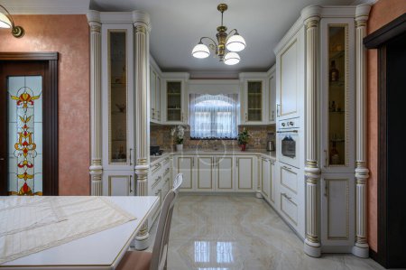 Téléchargez les photos : White classic cozy kitchen and dining room in city house interior, front view - en image libre de droit