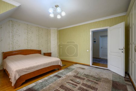 Téléchargez les photos : Intérieur d'une chambre spacieuse mais confortable dans un style rustique avec grand lit double - en image libre de droit