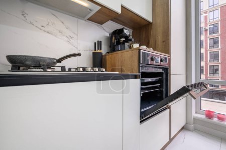 Photo for Large black and white modern luxury kitchen interior, closeup view to kitchen counter and to open oven door - Royalty Free Image