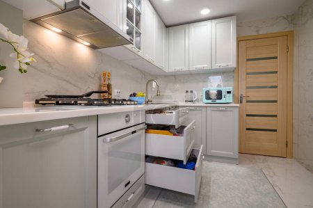 Téléchargez les photos : Gros plan sur blanc et gris nouvelle cuisine moderne bien conçu intérieur, certains tiroirs retirés - en image libre de droit