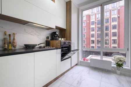 Téléchargez les photos : Grand intérieur de cuisine moderne de luxe noir et blanc, vue rapprochée sur le comptoir de cuisine et pour ouvrir la porte du four - en image libre de droit