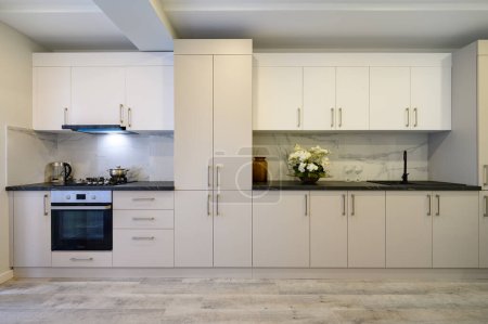 Téléchargez les photos : Intérieur d'une grande cuisine spacieuse de luxe beige et crème, vue sur les meubles - en image libre de droit