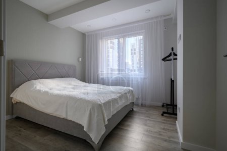 Foto de Interior de un pequeño dormitorio blanco brillante con cama doble grande - Imagen libre de derechos