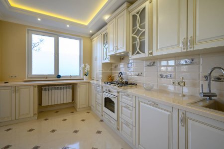 Téléchargez les photos : Cuisine classique blanche et beige luxueuse dans studio intérieur - en image libre de droit