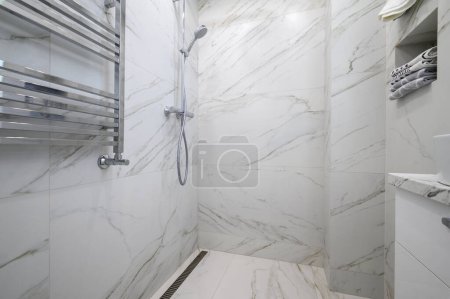 Photo for White bathroom interior with marble tiles on the walls and shower - Royalty Free Image