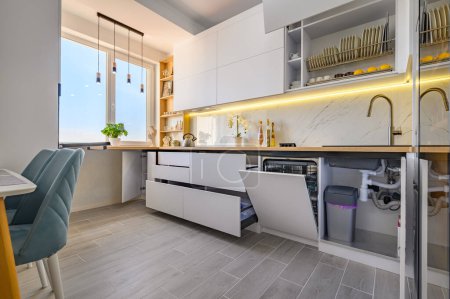 Téléchargez les photos : A modern trendy white kitchen with drawers pulled out to their full length - en image libre de droit