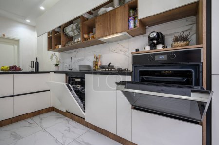 Téléchargez les photos : Grand intérieur de cuisine moderne de luxe noir et blanc, vue rapprochée pour ouvrir la porte du four - en image libre de droit