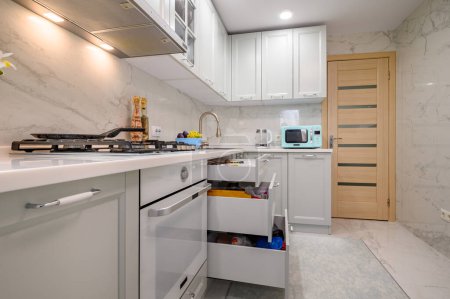 Photo for Closeup to white and grey new modern well designed kitchen interior, some drawers pulled out - Royalty Free Image