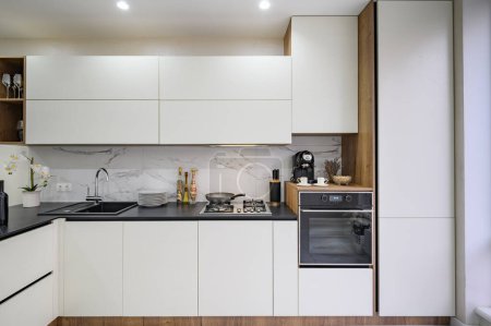 Téléchargez les photos : Large white and black luxury kitchen interior, front view - en image libre de droit