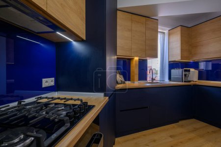 Téléchargez les photos : Details of blue and wood colored kitchen closeup to kitchen counter - en image libre de droit