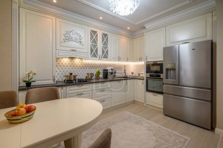 Foto de Cocina clásica de color beige con amplio espacio de mostrador y una variedad de electrodomésticos - Imagen libre de derechos