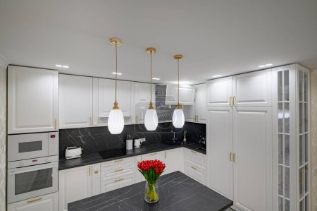 Téléchargez les photos : Luxury large modern domestic kitchen furniture with island and black marble worktop - en image libre de droit