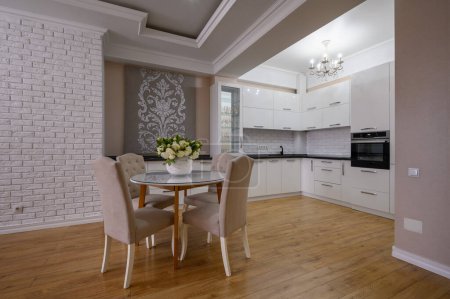 Téléchargez les photos : Cuisine moderne blanche de luxe avec murs roses et blancs et parquet stratifié dans un studio - en image libre de droit