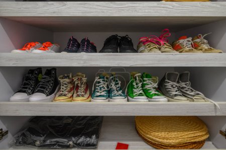 Téléchargez les photos : Open big white wardrobe with different shoes at shelves - en image libre de droit
