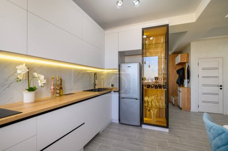 Ein modernes weißes Studio mit einer voll ausgestatteten und einsatzbereiten Küche