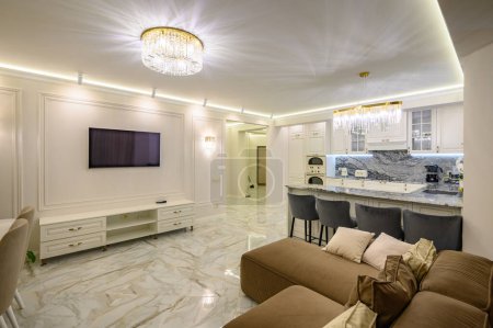 Studio-Apartment mit klassischer Küche mit Insel als Essbereich und Fernseher an der Wand