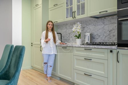 Photo for Portrait of young cute housewife in the kitchen interior at background - Royalty Free Image