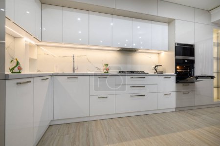Téléchargez les photos : Interior of a modern white kitchen in luxury studio apartment, close-up view of kitchen furniture - en image libre de droit