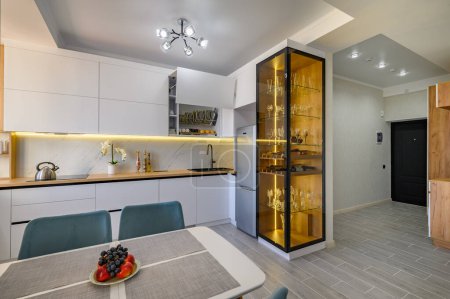 Foto de A fashionable white studio with a modern kitchen and a sleek glass sideboard - Imagen libre de derechos