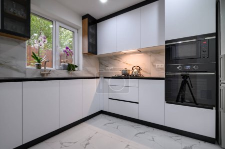 Foto de A newly renovated kitchen with modern appliances, marble flooring, and stylish finishes - Imagen libre de derechos