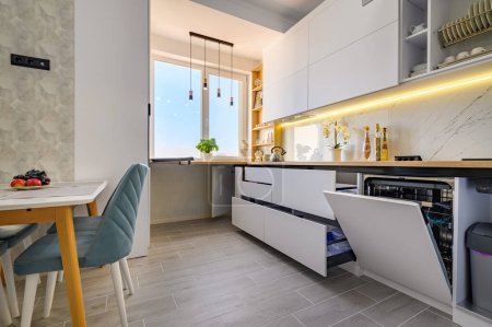 Téléchargez les photos : A chic modern white kitchen with drawers fully extended - en image libre de droit