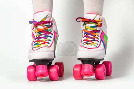 Foto de Retrato de piernas de mujer con patines de cuatro ruedas con cordones de colores sobre fondo blanco - Imagen libre de derechos