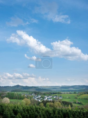 white houses in village near schmallenberg in spring and surrounding countryside of Sauerland in Germany
