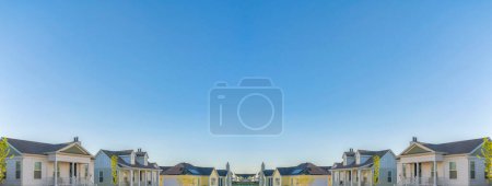 Photo for Abstract mirrored background Two white and two yellow houses with traditional design at Daybreak, South Jordan, Utah. There are two white houses on the left and two yellow - Royalty Free Image