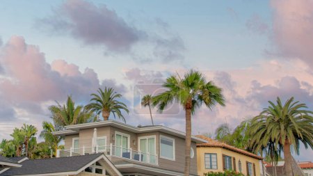 Photo for Panorama Puffy clouds at sunset Low angle view of residential houses at La Jolla, California. There are palm trees outside the neighborhood with different architectural designs against the sky background. - Royalty Free Image