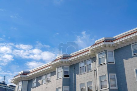 Photo for Apartment building with painted gray concrete tiles wall cladding in San Francisco, California. Building exterior with bay and single hung windows against the sky background. - Royalty Free Image