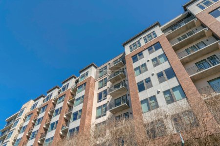 Photo for Austin, Texas- Low angle view of a mid-rise apartment building. Facade of an apartment complex with balconies and picture windows. - Royalty Free Image