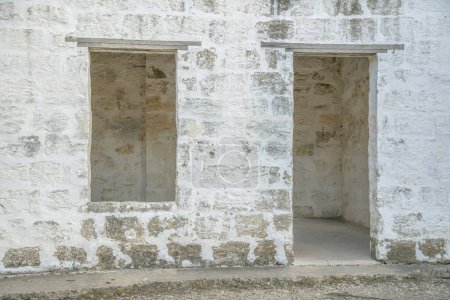 Foto de San Antonio, Texas- Edificio exterior abandonado sin puerta y sin ventanas. Fachada de un antiguo edificio con paredes de bloques de piedra blanca envejecida. - Imagen libre de derechos