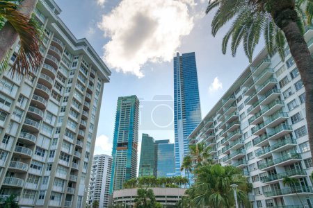 Photo for Miami, Florida luxury residences under the bright clouds in the sky. There are two mid-rise condos on both sides at the front and high-rise buildings in the middle. - Royalty Free Image