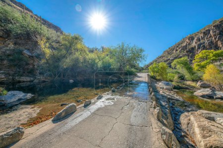 Téléchargez les photos : Eau coulant sur le pont au milieu des montagnes rocheuses du désert au Sabino Canyon State Park. Parc naturel de Tucson, AZ avec pont en béton près des montagnes avec cactus saguaro. - en image libre de droit