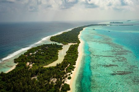 Téléchargez les photos : Une île tropicale aux Maldives avec de l'eau de mer turquoise. Destination touristique de vacances de voyage. Paysage marin pittoresque. Tournage vidéo avec un drone. - en image libre de droit
