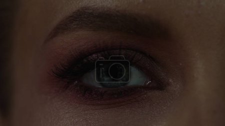 Foto de Primer plano de abrir el ojo femenino con maquillaje. La reacción del ojo a la luz. Vista frontal de cerca. vídeo en 4K. - Imagen libre de derechos