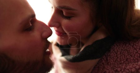 Foto de Una joven pareja enamorada se despide con besos y abrazos apasionados después de una cita romántica en el pasillo de un edificio de apartamentos. - Imagen libre de derechos