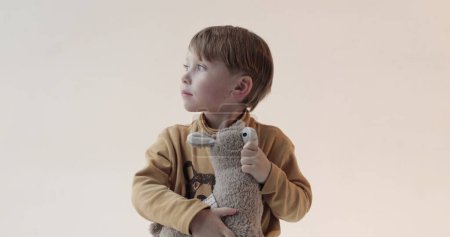 Foto de Retrato de un niño pequeño con un juguete suave en sus manos. Disparos en el estudio - Imagen libre de derechos