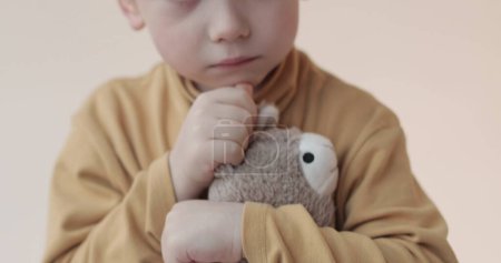 Foto de Retrato de un niño pequeño con un juguete suave en sus manos. Disparos en el estudio - Imagen libre de derechos