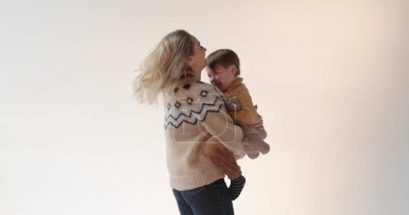 Foto de Una madre con su hijo en brazos en el estudio. Feliz madre de un hermoso hijo. Retrato de madre e hijo en el estudio. - Imagen libre de derechos