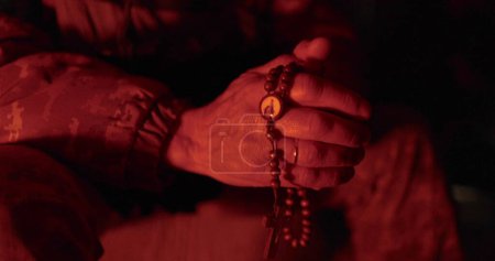 Foto de Los soldados rezan con rosarios en sus manos. Primer plano de las manos del vicario con rosario durante la oración. Rezaron por el tiempo militar. El hombre reza. - Imagen libre de derechos