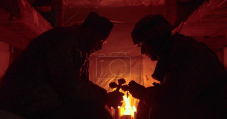 Foto de Confesión de un soldado ucraniano en un oscuro foso. El capellán y el alcaide se sientan uno frente al otro y hablan. - Imagen libre de derechos